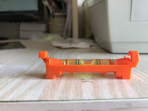 Side view of a Seven Piece Hanging Bubble Line Level Set For Building Trades And Surveying Durable ABS Plastic Three Inch Length.