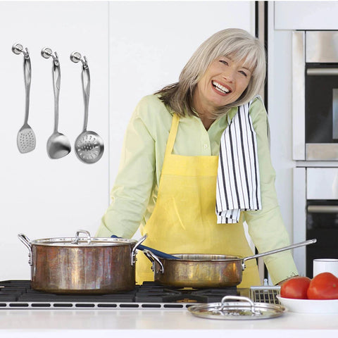 Woman cooking in kitchen with stainless steel utensils and pots on the stove