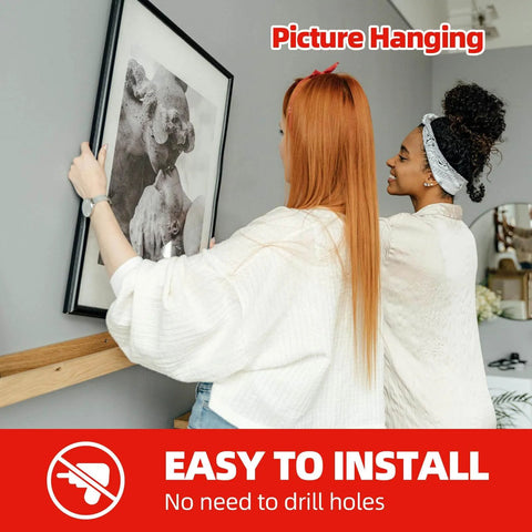 Two women using Heavy Duty Double Sided Foam Tape 0.39 Inch Wide By 9.85 Feet Long Removable Mounting Tape to hang a picture.