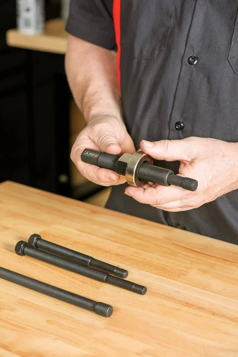 Person holding Master Harmonic Balancer Install Kit For Domestic And Import Vehicles With Extra Long Installers on a table