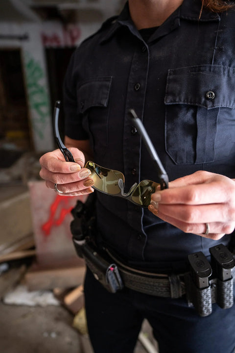 Person holding Harrier Interchangeable Shooting Glasses With 4 Lens Sets And Anti Fog Lenses in urban setting