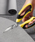 Heavy Duty 8 Inch Utility Scissors with Serrated Blades cutting gray carpet, showcasing ergonomic grip for multipurpose use in home or workshop.
