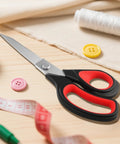 Heavy Duty All Purpose Fabric Scissors For Sewing And Garment Making With Stainless Steel Blades on a sewing table with measuring tape and thread.