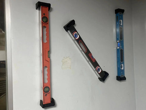 Heavy Duty Level Holder And Bracket Storage Rack 4 Pack Universal Wall Mount For Rulers And Tools installed on a wall