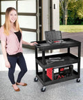 Heavy Duty Plastic Utility Cart For Warehouses And Workshops With Three Shelves 32 By 18 Rolling Tub Cart 300 Lb Capacity Ergonomic Push Handle Black By Luxor Built For Tough Jobs Hauls Heavy Loads In Warehouses Garages Shops Cafes And More in a garage setting with tools.