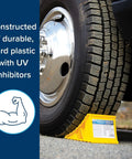 Heavy duty yellow plastic wheel chock for trailers and RVs under a tire, UV-protected, fits up to 26-inch tires, keeping it in place.