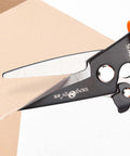 Heavy Duty 9 Inch Multipurpose Scissors With Serrated Edge cutting cardboard, featuring spring loaded steel shears for industry and home use.