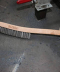 Wire Brush, Heavy Duty Stainless Steel Wire Brushes for Cleaning Rust, 14" Long Beech Handle shown on industrial surface