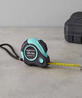 Heavy Duty Tape Measure - 16 ft / 192 in, Turquoise with yellow blade extended on gray surface