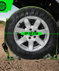 Heavy Duty Wheel Chock Tie Down Straps Set Two Pack With 4,400 Lb Max Break Strength And 2 Inch By 6 Foot Trailer Tire Straps Plus Four Wheel Chocks For ATVs UTVs Mowers And Tractors Safe E Track Compatible shown securing a wheel
