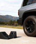 Heavy Duty Wheel Chocks For Cars And Travel Trailers, Stackable Space Saving Anti Slip Wedges With Rock Solid Grip next to SUV tire