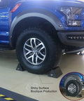 Heavy Duty Wheel Chocks 2 Pack For Travel Trailers With Eyebolt under a blue truck, Brazilian Natural Rubber