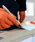 Person painting wood while wearing Hi Vis Orange Nitrile Gloves Raised Diamond Texture 8 Mil Large Box Of 50