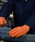 Mechanic wearing Hi Vis Orange Nitrile Gloves Raised Diamond Texture 8 Mil Large Box Of 50, using tools on metal part