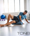 Man using High Density EPP Foam Exercise Roller For Yoga Pilates Stretching Massage And Recovery 36 Inch Black for leg massage