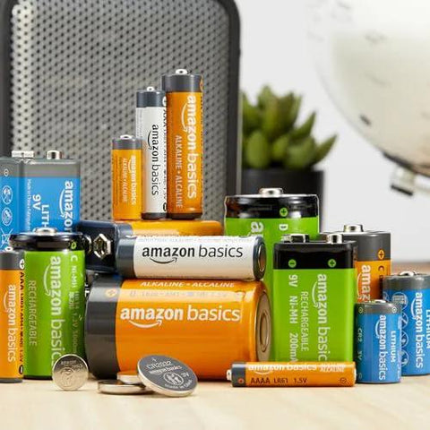 Assorted alkaline and rechargeable batteries, including AA and AAA, displayed on a table; related to 24 Pack 12 AA And 12 AAA High Performance Alkaline Batteries Value Pack.