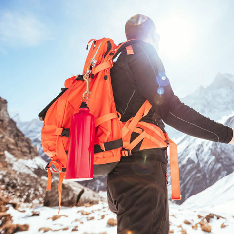 Hiker with orange backpack using 4 Pack 3.5 Inch Brass Double Ended Bolt Snap Clips on a snowy mountain trail