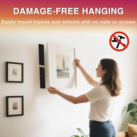 Person hanging a frame using damage-free hook-and-loop tape, illustrating use for mounting without nails or screws.