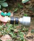 Hand holding a metal hose connector from the Garden Hose Quick Connect Fittings Set 3/4 Inch GHT Male And Female Metal Hose Connectors