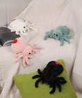 Super Soft Pink Spider Plush Toy For Kids And Adults with other plush spiders on blanket and pillow