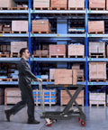Warehouse worker using Hydraulic Lift Table Cart 500 Lb Capacity With 28.5 Inch Lift And Four PU Wheels For Safe Material Handling