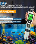 Hydrogen Water Tester 4 In 1 PH H2 ORP And Temp PH Meter in hand, displaying ORP readings above aquarium, ideal for water quality checks.