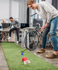 Person practicing putting with Practice Golf Balls 24 Pack, 42mm Plastic Golf Balls in a multicolor set on an indoor green in an office space.
