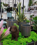 Indoor display of Rust Resistant Iron Plant Pot Stand Set for Indoor and Outdoor Use with decorative planters, plants, and ornament.