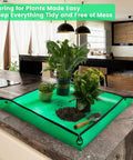 Indoor Plant Repotting Mat For Transplanting And Mess Control, Waterproof 26.8 Inch Square Potting Tray on kitchen counter with plants and soil.