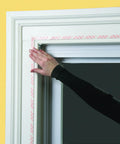 Person installing Indoor Window Insulation Kit 4 Pack Shrink Film For Windows With Included Double Sided Tape And Hair Dryer
