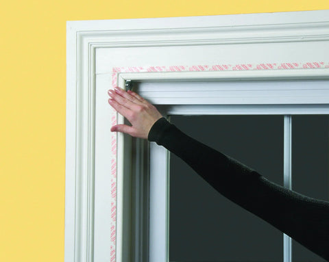 Person installing Indoor Window Insulation Kit 4 Pack Shrink Film For Windows With Included Double Sided Tape And Hair Dryer