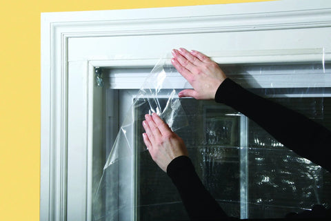 Applying shrink film from Indoor Window Insulation Kit 4 Pack Shrink Film For Windows With Included Double Sided Tape And Hair Dryer For Easy Installation.