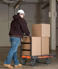 Worker pushing a cart with boxes using 8x2 Inch Heavy Duty Caster Wheels Set Of 4 Up To 3600 Pound Capacity Industrial Rubber Flat Tread Casters