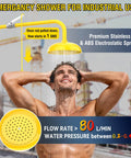 Estación de ducha y lavaojos de emergencia de grado industrial con aprobación OSHA y cumplimiento con ANSI Z358.1 2014 304 Stainless Steel Construcción con amarillo ABS Kit combinado de ducha de primeros auxilios y señal de emergencia para laboratorios de construcción, en uso por una persona que se ducha al aire libre.