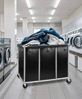 Industrial Laundry Cart On Wheels With 420L Capacity in a commercial laundromat, loaded with linens, showing heavy duty steel frame and wheels.