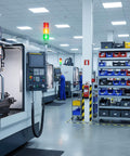 Línea de producción industrial con torre de señales Andon LED de tres niveles y zumbador integrado, con indicadores rojos, amarillos y verdes visibles