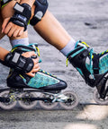 Person wearing blue inline skates with bearings adjusting gear outdoors