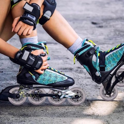 Person wearing blue inline skates with bearings adjusting gear outdoors