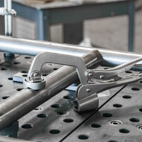 Heavy Duty Five Eighths Inch Insert Table Mounted Clamp With Rear Crank Handle For BuildPro Welding Tables in use on metal pipe