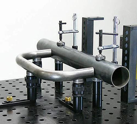 Inserta Clamp For Eight And A Half Inch Capacity By Build Pro UEN5200 holding metal pipe securely on a perforated table.