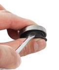 Close-up of hand holding bike bearing and axle protection cover with tool, from Two Pack Black Axle Protection Covers for Bike Bearings Dust Covers