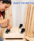Person installing 1.5 Inch Ball Caster Wheels for Furniture Swivel Casters with screwdriver on wooden furniture.