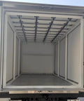 Rear view of an empty industrial container truck showing interior rails for heavy load transport and smooth silent sliding material handling.