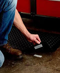 Person installing Extreme Interlocking Fasteners That Bond On Contact, 4 Strips 1 Inch By 3 Inches on a workshop floor mat.