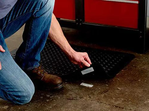 Person installing Extreme Interlocking Fasteners That Bond On Contact, 4 Strips 1 Inch By 3 Inches on a workshop floor mat.
