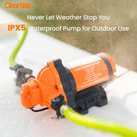 Orange Cleartide Diaphragm Water Pump, 115V, 3.3 GPM, 50 PSI, Self-Priming 10FT, being sprayed with water, outdoor use