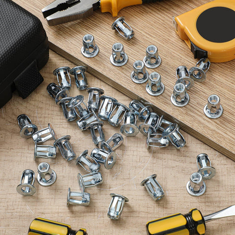 50 Pack Jack Nuts 1/4-20 Threaded Inserts Petal Nuts And Blind Fasteners For Plastic And Metal Projects Zinc Plated Steel And Aluminum Alloy Dowels Screw Anchors For Hollow Plates Pipes Sheets And More, scattered on a wooden surface with tools in the background.