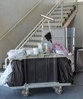 Industrial cleaning cart with supplies on heavy duty caster wheels set of 4 6x2 flat tread rubber casters near stairs