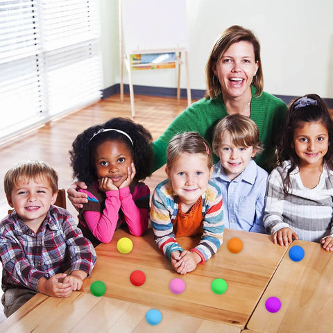 Children and a teacher with 100 Pack Table Tennis Balls,40mm Colored Plastic Balls Beer Balls Bulk for games and crafts on a table.