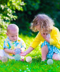 Kids playing with 50 Balls Soft Plastic Ball Pit Balls for Kids in pastel macaron colors on grass, gift for baby toddler birthday Christmas.